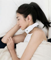 Woman lying down using a multifunctional remote control neck massager.
