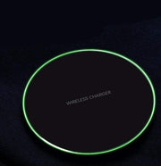 Wireless charger with green LED ring, black surface, for fast charging iPhone and Samsung devices.