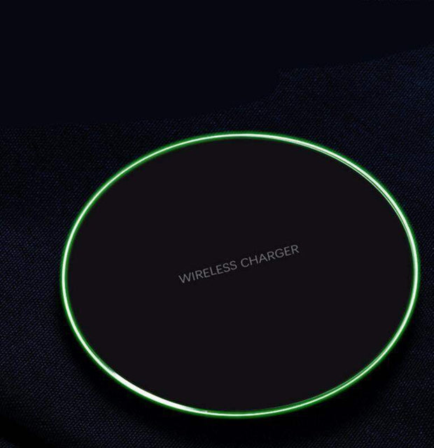 Wireless charger with green LED ring, black surface, for fast charging iPhone and Samsung devices.