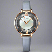 Ladies fashion watch with gray leather strap and round dial.