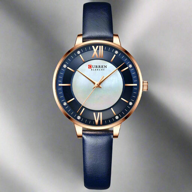 Ladies fashion watch with dark blue leather strap, quartz movement, and rose gold case with a round dial.