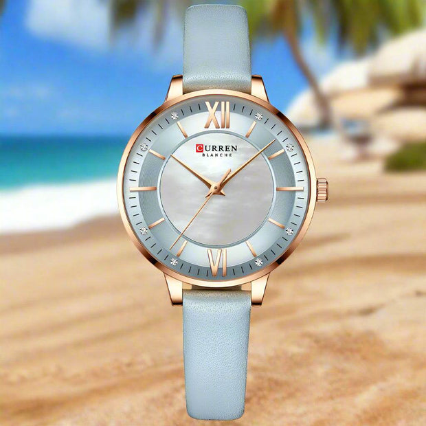 Ladies fashion watch with light blue genuine leather strap, round alloy case, quartz movement, and casual style.