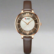 Ladies fashion quartz watch with brown leather strap and round alloy case.