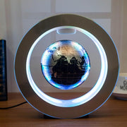 Round LED world map floating globe with magnetic levitation light on brushed silver O shape base.