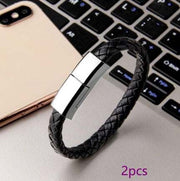 Black braided leather bracelet charger USB cable on a laptop keyboard.