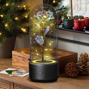 Rose flowers LED light and Bluetooth speaker in glass cover on a holiday-themed table.