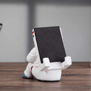 Cute astronaut phone stand made of resin on a desk, creative and stylish desktop holder.