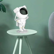 Astronaut galaxy projector on table with green background, USB-powered starry sky lamp for bedroom decor.