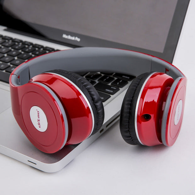 Wired gaming headphone with red and black design resting on a laptop, featuring heavy bass and universal compatibility.