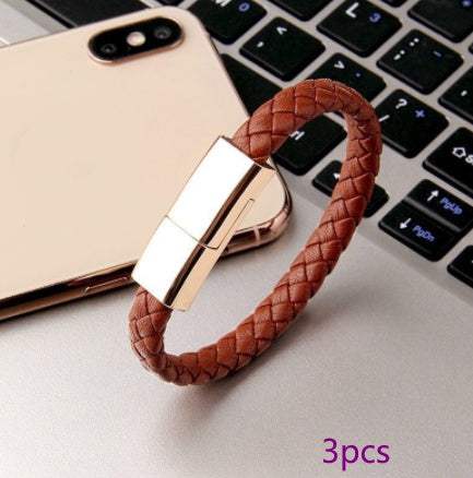 Brown braided leather bracelet charging cable on laptop keyboard.