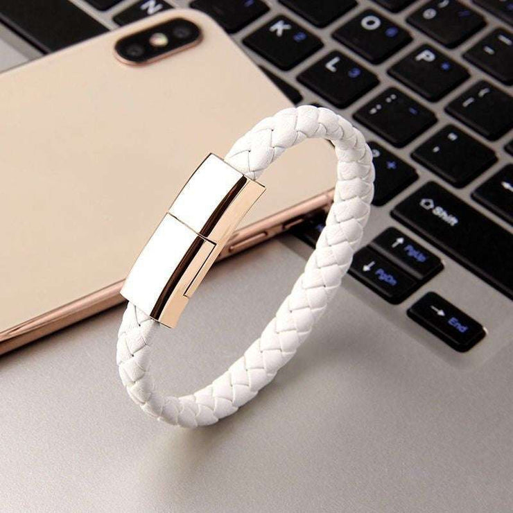 USB charging bracelet on laptop, white braided design with metallic connectors.