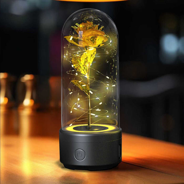 Creative 2-in-1 rose LED light and Bluetooth speaker ornament in a glass cover on a table.