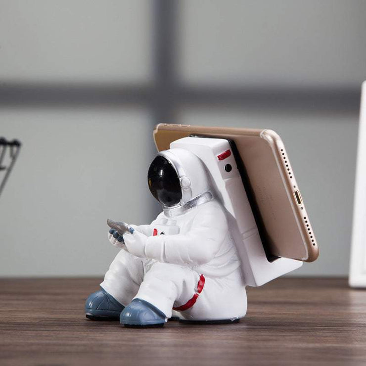 Cute astronaut phone stand as a creative desktop holder and small desk decoration.