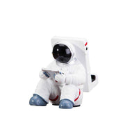 Cute astronaut phone stand made of resin, ideal for small desks.