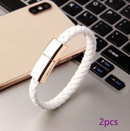 Braided leather bracelet charger with USB connector on a laptop.